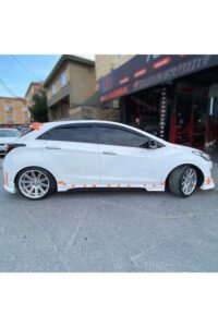 Yol kenarında park etmiş beyaz performans otomobili, modifiye ve yarış otomobili parçaları ile detaylandırılmış.